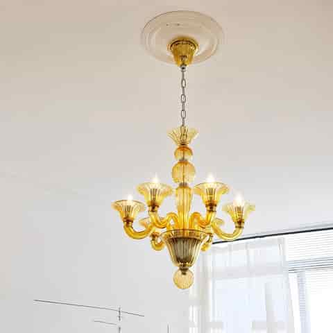 Amber colored glass chandelier with curved arms and chain suspension