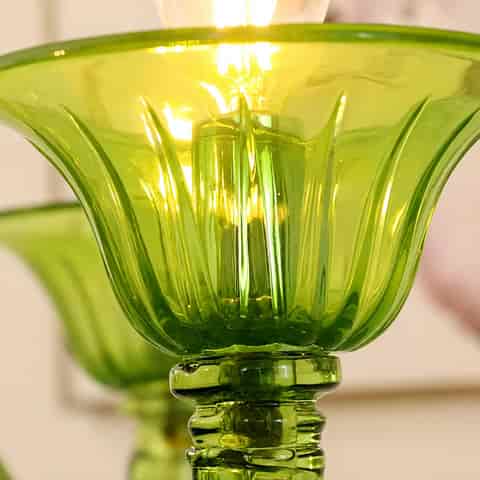 mber glass chandelier close up with ribbed candle cups and curved arms