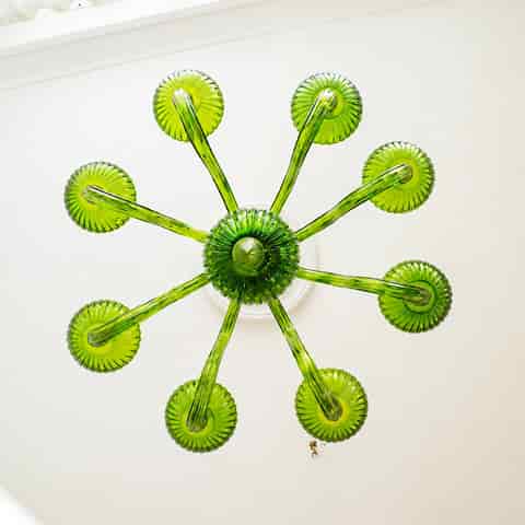 Top view of green glass 8 arm chandelier with ribbed glass details