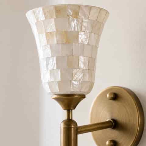 Front view of vintage brass wall sconce with flared natural shell mosaic shade