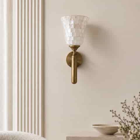 Natural shell mosaic wall sconce with antique brass finish in a warm modern hallway