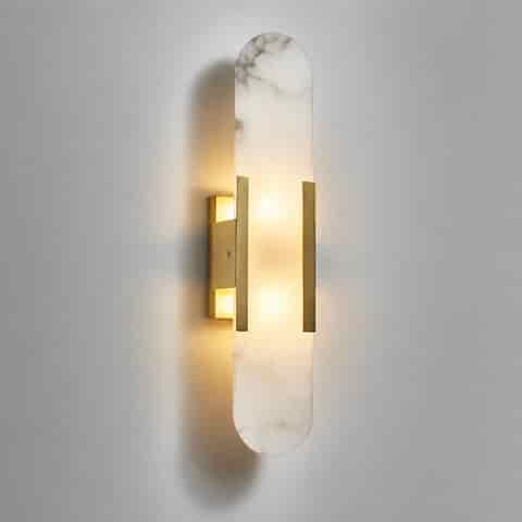Modern vertical alabaster wall sconce with rounded stone panel and gold metal accents