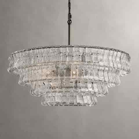 Clear glass tiered chandelier with a gold tone metal chain and layered curved glass panels