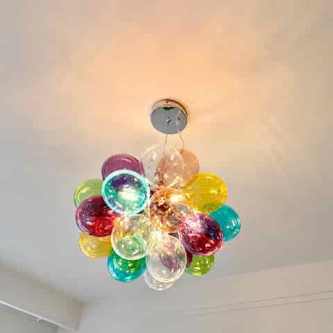 Upward installation view of colorful bubble chandelier with transparent multicolor globes