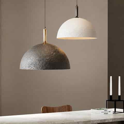 Black and white textured dome pendant lights displayed above a modern dining counter