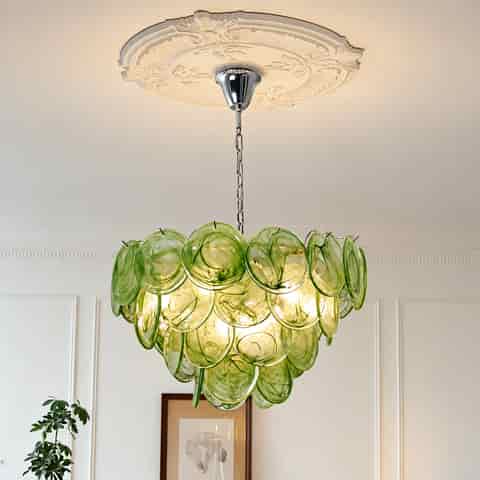 Green Murano glass chandelier with layered translucent discs in an elegant room featuring decorative ceiling molding