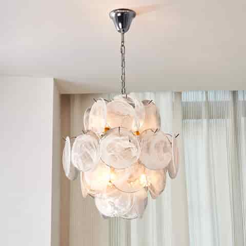 White Murano glass chandelier with sculptural layered glass discs and warm light, suspended from a chrome ceiling canopy