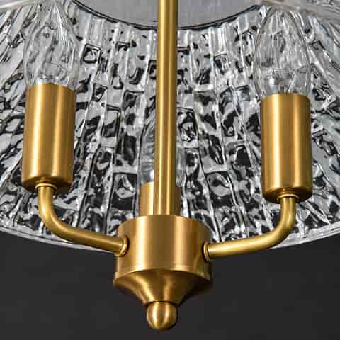 Close Up of Gold Finish Metal Arms, Three Lamp Holders and Textured Glass Pendant Shade