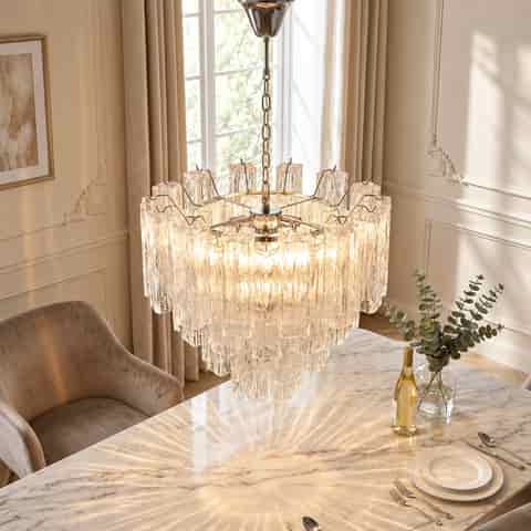 Chrome metal chandelier with layered textured glass shades above an elegant dining table in a contemporary home