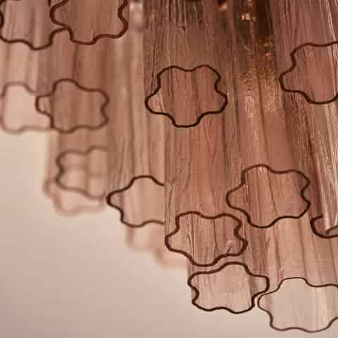 Close up of pink textured chandelier shades showing translucent surfaces, vertical ripples, and flowing pink patterns