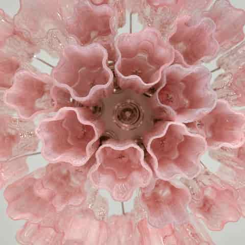Top view of a pink multi tier chandelier showing scalloped tube openings and the circular arrangement of its shades