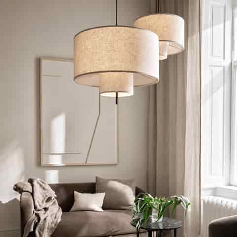 Layered linen drum pendant lights in a warm neutral modern living room