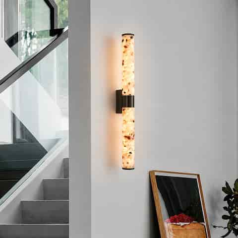 Long terrazzo and blackened brass LED wall sconce beside a modern staircase