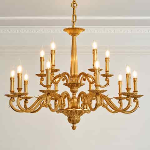 Large ornate gold multi light chandelier with layered scrolling arms and elaborate classical decorative details