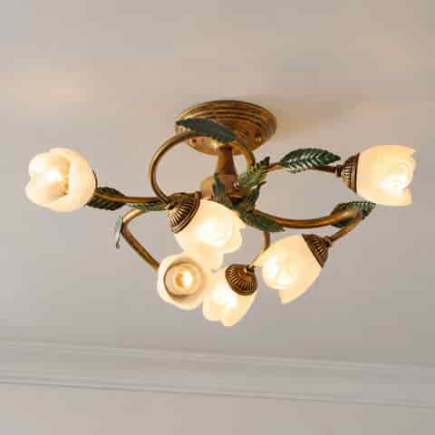 Underside detail of a vintage floral ceiling light with warm white flower shaped shades and decorative metal fittings