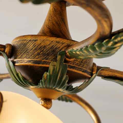 Close up of the vintage textured metal ceiling light frame with sculpted green leaf ornamentation