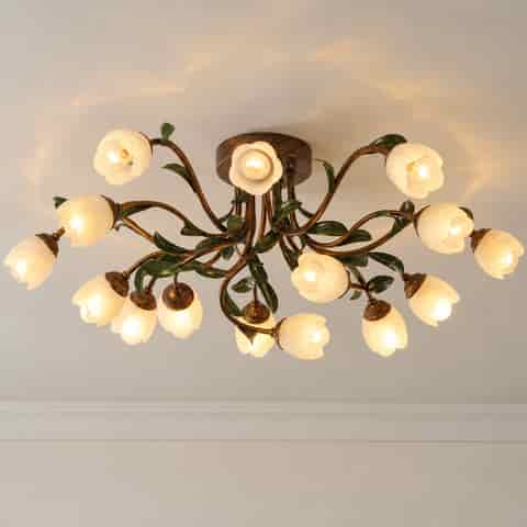Full view of a vintage floral ceiling light with branching bronze arms, botanical leaves, and glowing flower shades