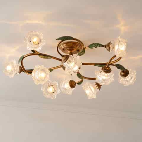 Vintage floral glass ceiling light with bronze branches and green leaves, multiple glowing flower shades
