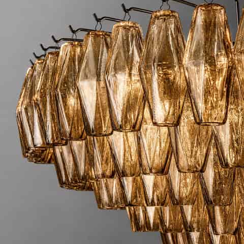 Close up of textured amber glass chandelier pendants with faceted surfaces and individual