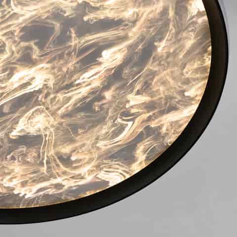 Close up of the matte black outer frame and translucent patterned diffuser of a modern ceiling light