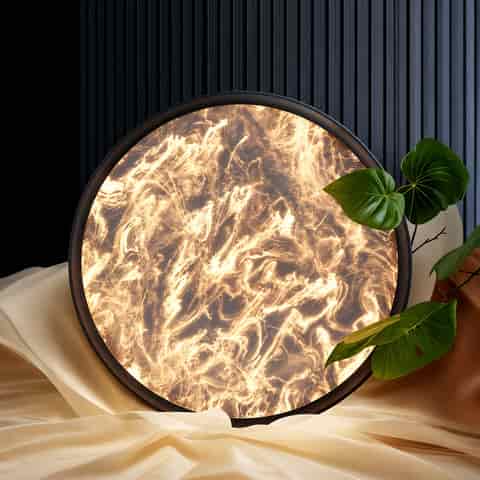 Black round flush mount ceiling light with a glowing swirling marble effect diffuser in a modern bedroom