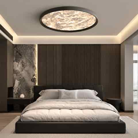 Black modern flush mount ceiling light installed above a contemporary bedroom with a warm luminous diffuser