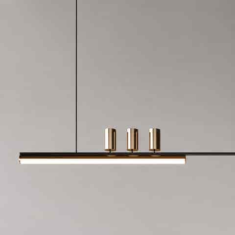 Close up of modern black and gold linear pendant light with integrated LED bar and three cylindrical metal light heads
