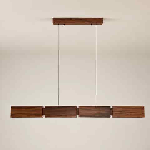 Front view of a walnut wood linear LED pendant with layered rectangular panels and minimalist suspension