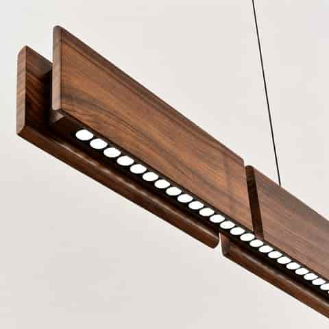 Close up underside view of walnut linear pendant with integrated LED lens array and layered wood construction