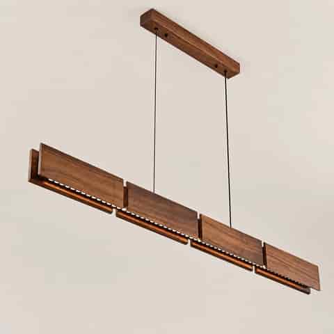 Walnut wood linear LED pendant showing concealed optical light modules beneath the layered wood panels