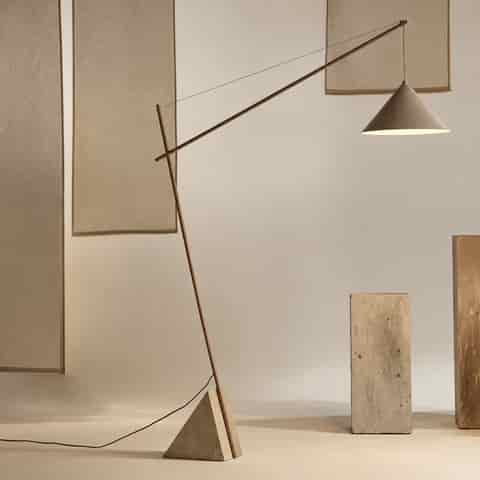 Full view of a contemporary marble cantilever floor lamp with an ivory beige iron structure and matching tapered iron shade