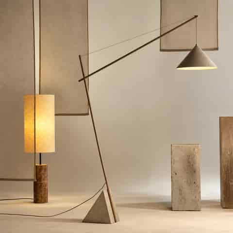 Modern marble cantilever floor lamp with a long diagonal iron arm, tension wire and sculptural tapered iron shade in a contemporary living room