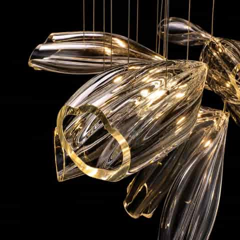 Detail view of illuminated transparent chandelier petals with organic curves, polished edges and