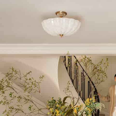 Sculptural white fluted glass and natural copper flush mount ceiling light installed in a refined transitional interior