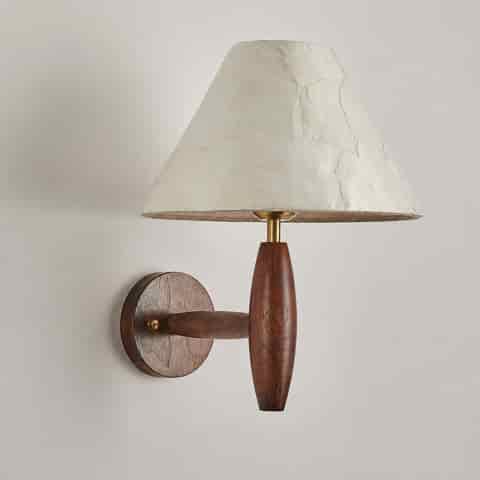 Close up of dark wood wall sconce body with brass accents and natural Capiz shell shade
