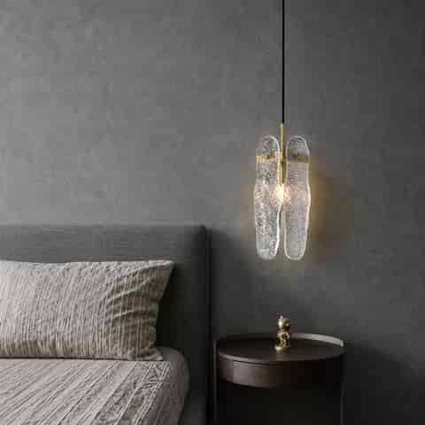 Close up of clear water ripple glass panel and brass finish mounting detail on pendant light