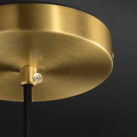 Close up of brushed brass finish ceiling canopy and black suspension cord for pendant light