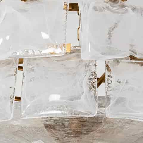 Close up of translucent textured glass panels and gold metal accents on a decorative chandelier