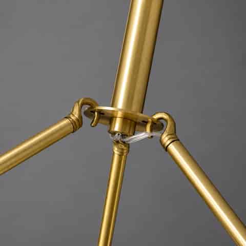 Close up of brushed brass chandelier suspension arms, central downrod and reinforced metal connection structure