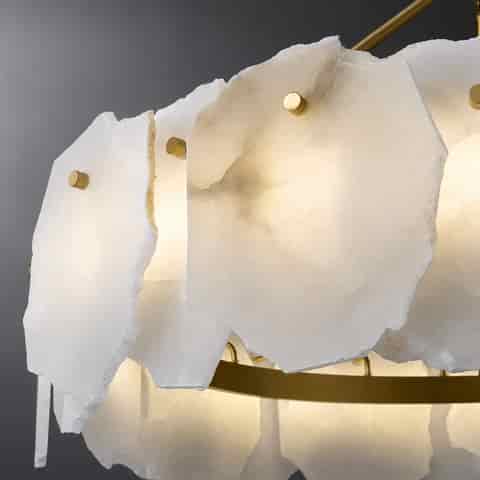 Detail of brass ring frame and individually mounted raw edge natural alabaster stone panels illuminated from behind