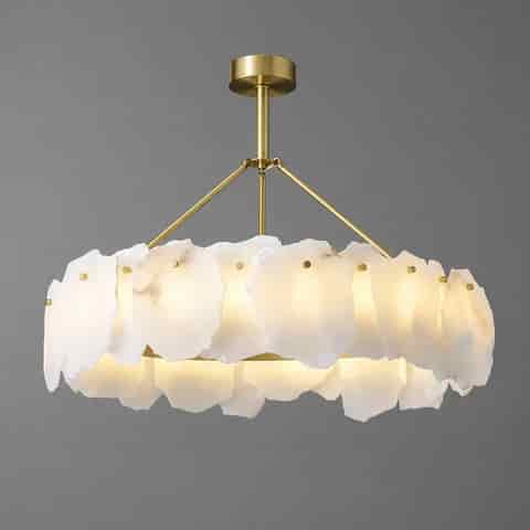 Natural alabaster stone chandelier with raw edge white panels, warm brass frame and softly diffused ambient light
