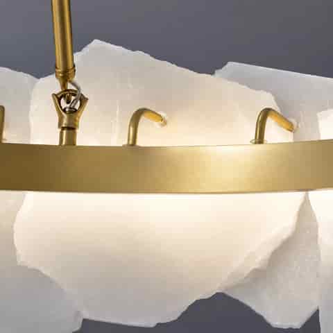Close up of natural alabaster chandelier showing translucent raw edge stone panels and brass mounting details