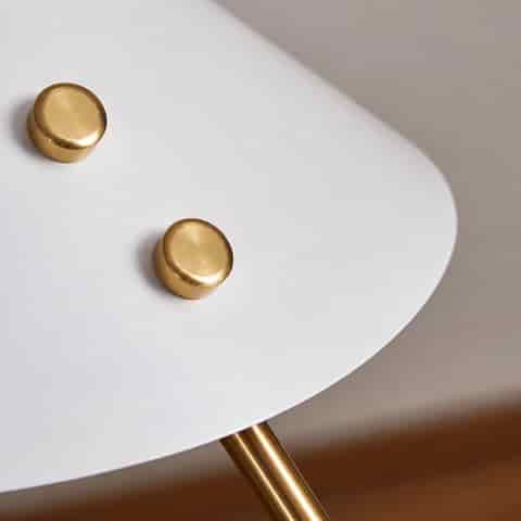 Top view of a white geometric metal lamp shade with polished gold mounting details