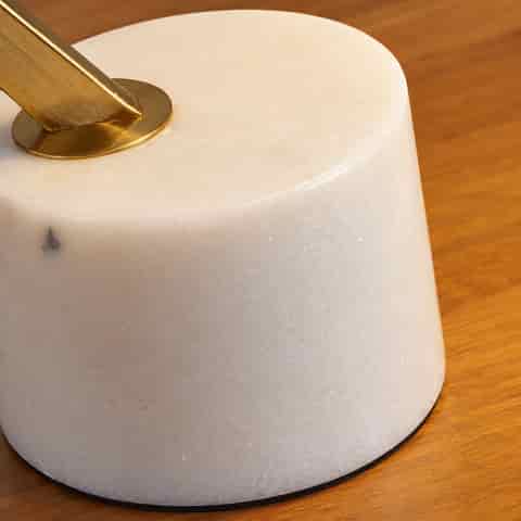 White cantilever table lamp with a geometric metal shade and natural stone cylindrical base